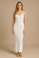 Woman wearing a white slip dress against a beige background