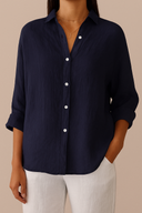 Navy blue button-up shirt worn by a person on a beige background