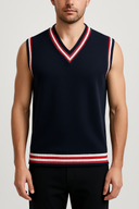 Man wearing a navy sleeveless sweater with red and white stripes on a light gray background