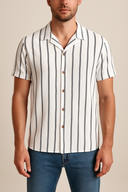 Man wearing a white and black striped shirt with short sleeves on a beige background