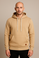 Man wearing a beige hoodie against a beige background