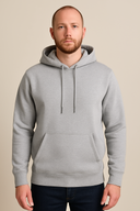 Man wearing a gray hoodie against a beige background