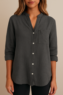 Dark gray button-up shirt worn by a person on a beige background