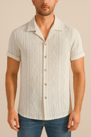 Man wearing a textured beige short-sleeve shirt against a neutral background