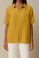 Yellow button-up shirt worn by a person on a beige background