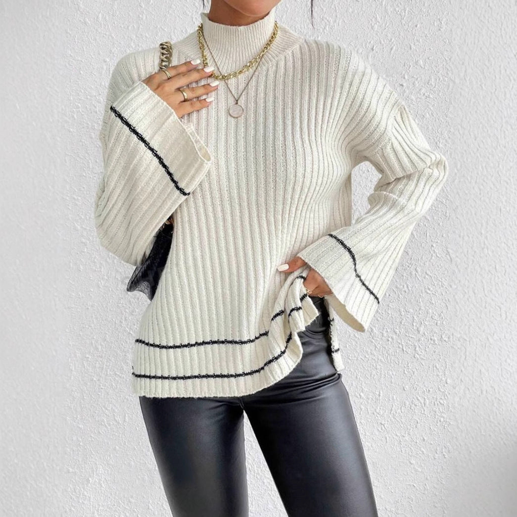 Person wearing a white ribbed sweater with black trim on a light gray background