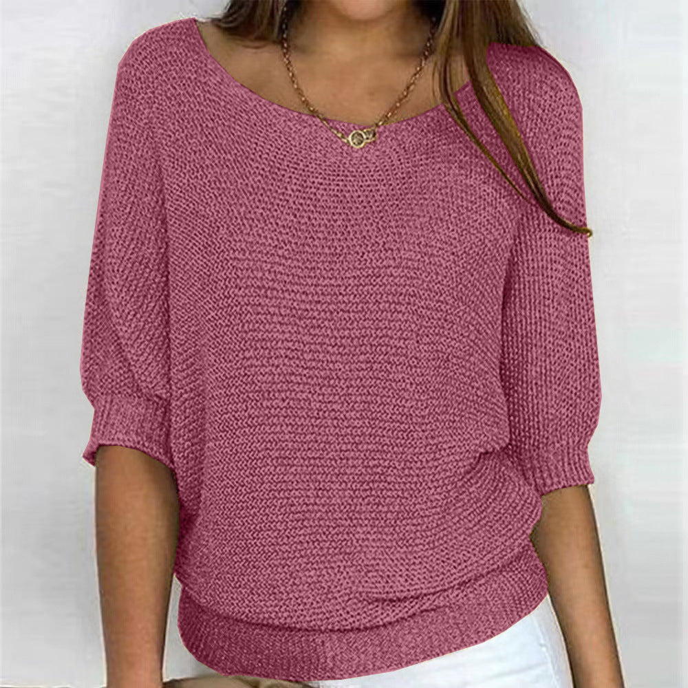 Person wearing a pink knitted sweater against a white background