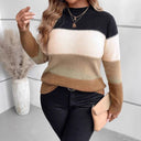 Person wearing a black, beige, and brown striped sweater holding a clutch.