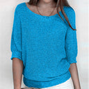 Person wearing a blue knitted sweater against a plain background