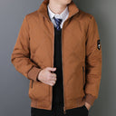 Brown quilted jacket worn by a person on a gray background