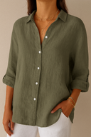 Person wearing an olive green button-up shirt with white pants against a beige background
