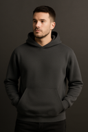Man wearing a black hoodie against a dark background