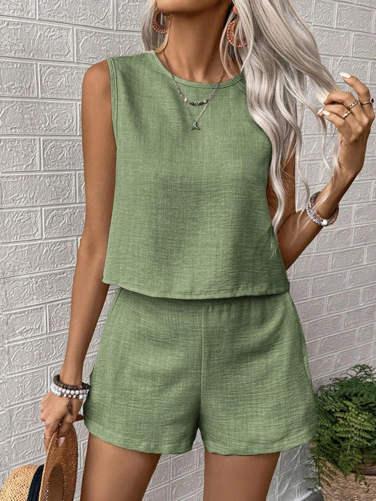 Woman wearing a green sleeveless top and shorts set against a textured wall.