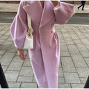 Person wearing a pink coat on a sidewalk