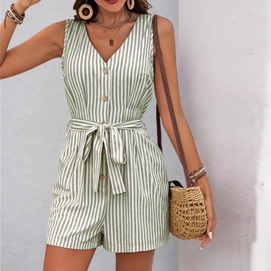 Woman wearing a green and white striped romper with a plain background