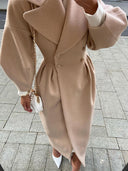 Person wearing a beige coat on a paved street