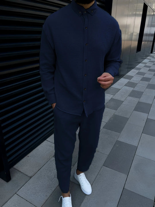 Person wearing a navy blue outfit with white sneakers on a checkered pavement.