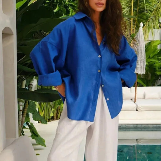 Person wearing a blue shirt and white pants in a tropical setting