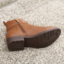 Brown boot with a zipper on a textured surface