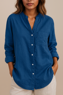 Person wearing a blue button-up shirt with a neutral background