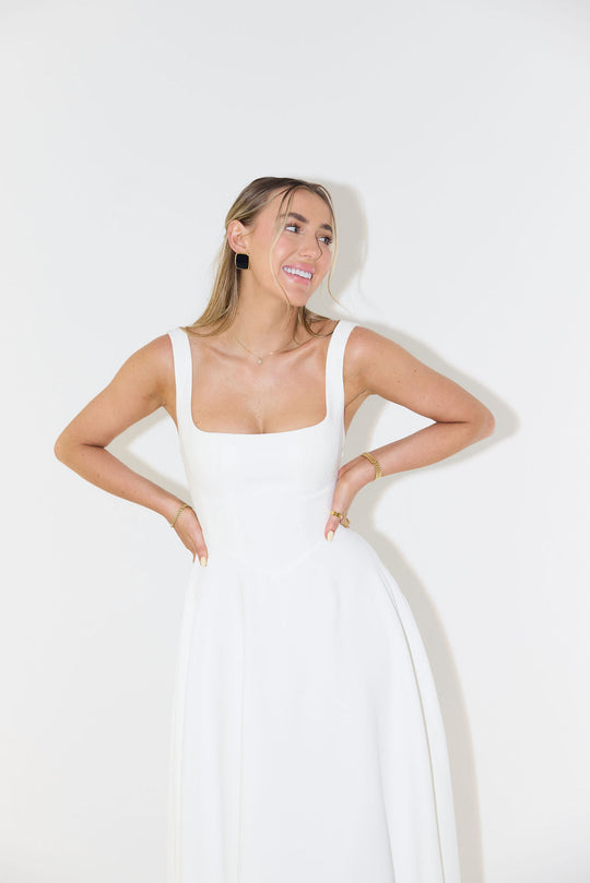 Woman wearing a white dress against a white background