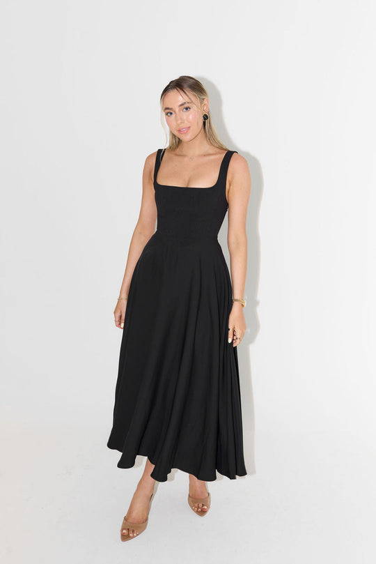Woman wearing a black sleeveless dress on a white background
