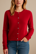 Red cardigan worn by a person on a beige background