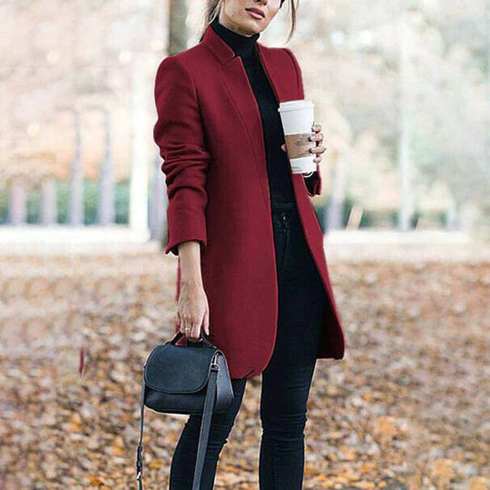 Woman wearing a red coat holding a coffee cup outdoors