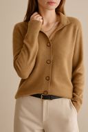 Brown button-up cardigan worn by a person on a beige background