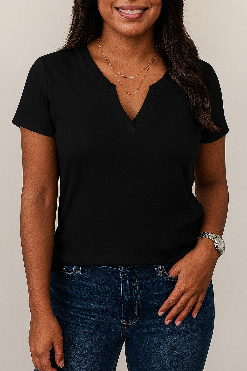 Person wearing a black t-shirt and blue jeans against a neutral background