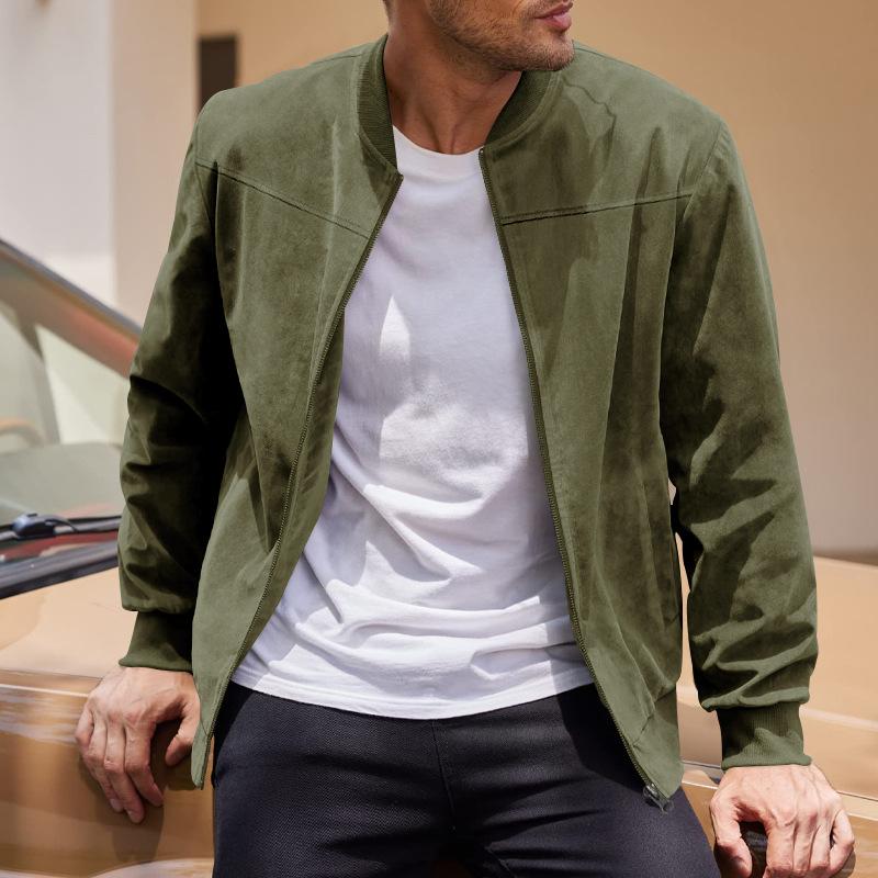 Man wearing a green jacket over a white shirt with a blurred background
