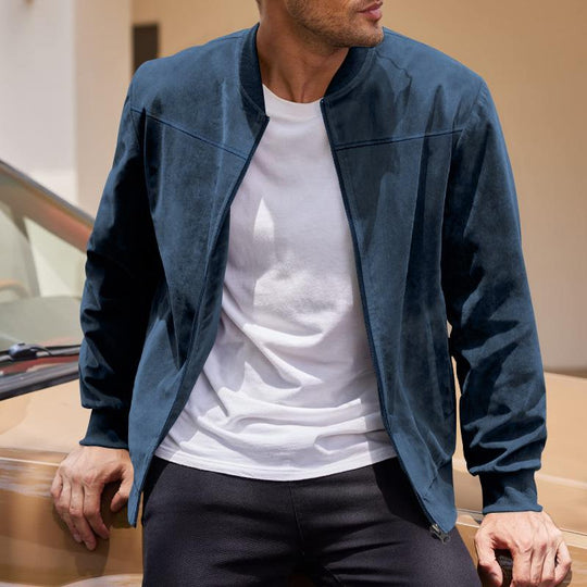 Man wearing a blue jacket over a white shirt, standing next to a car.