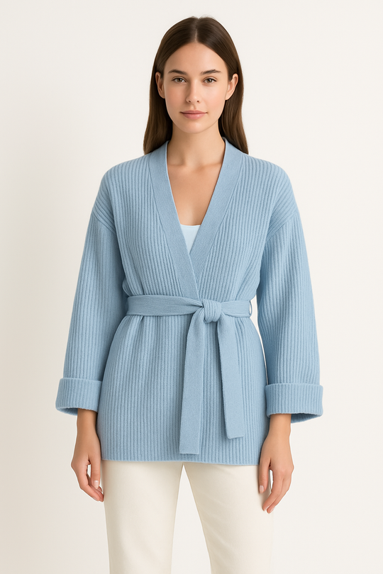 Woman wearing a light blue ribbed cardigan with a belt on a white background