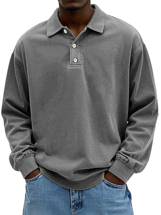 Person wearing a gray long-sleeve polo shirt with a white background
