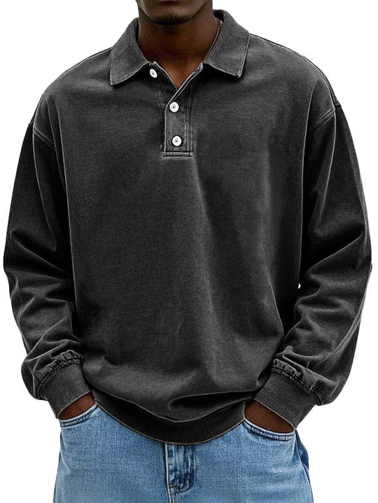 Person wearing a dark gray long-sleeve polo shirt with a collar.