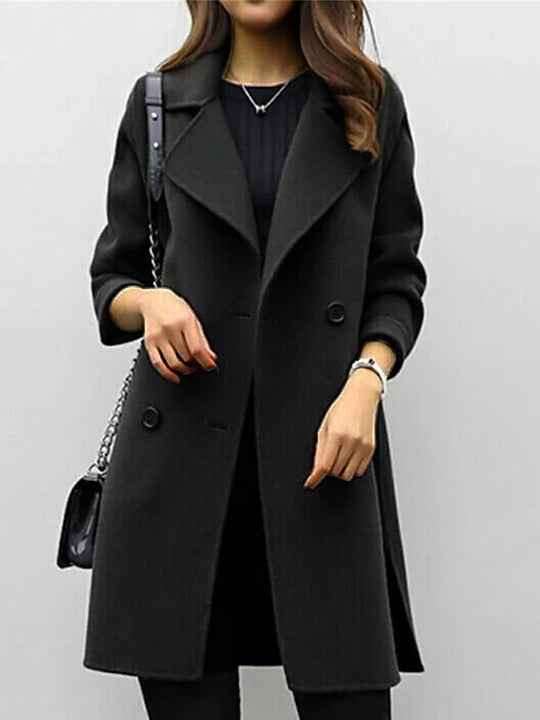 Person wearing a black coat with a plain background
